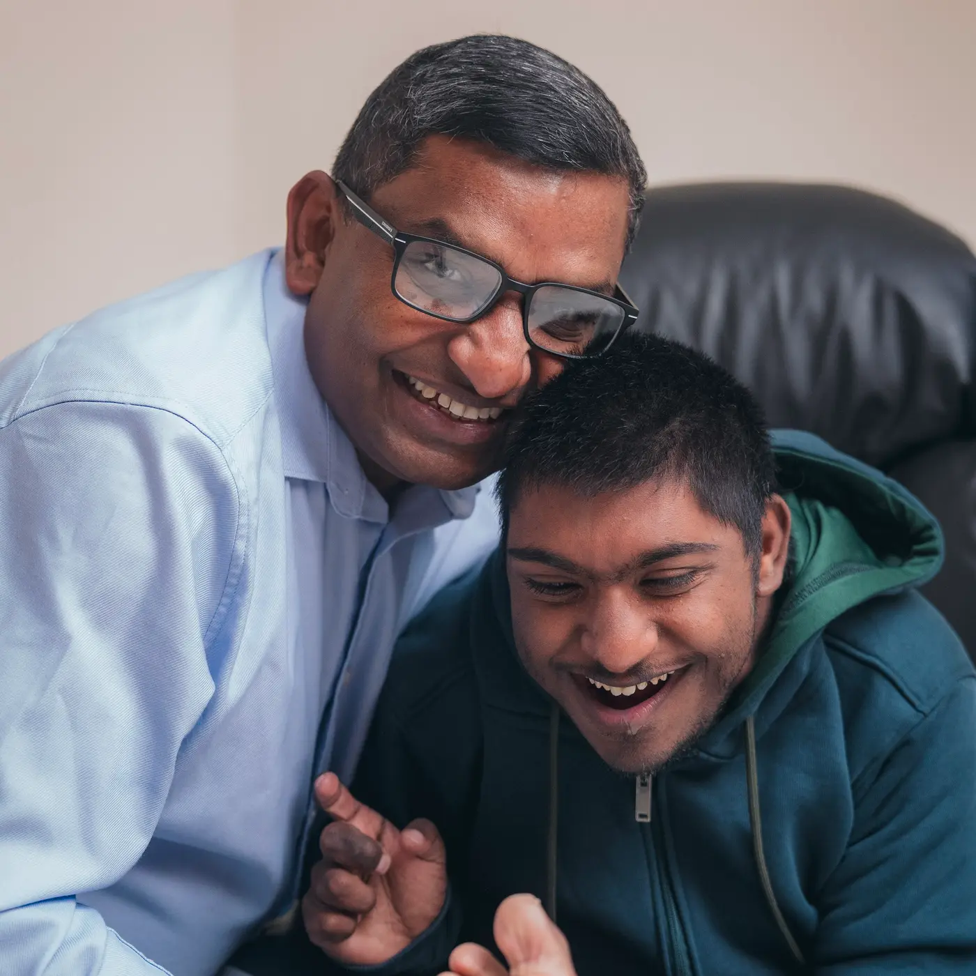 Bejoy with his arm around his son, both of them laughing